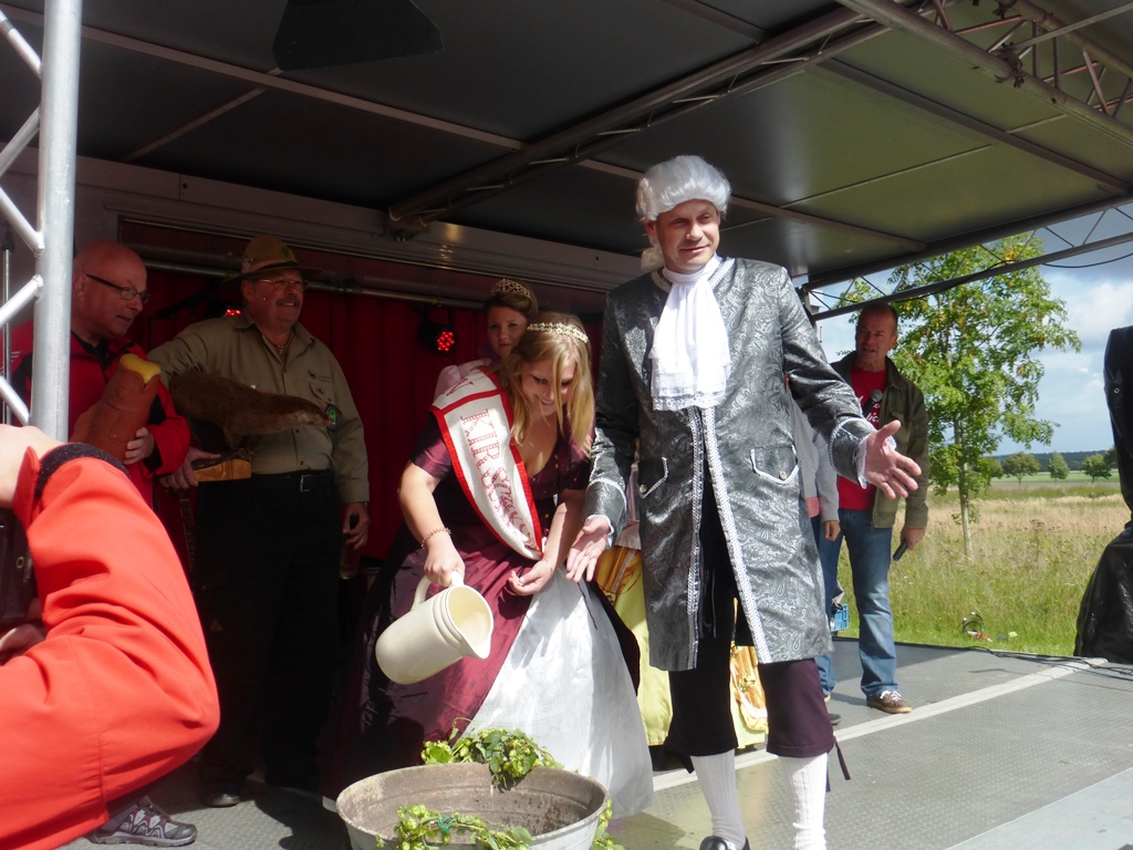 Kirschkönigin Celina gießt das Allerwasser in die Wanne